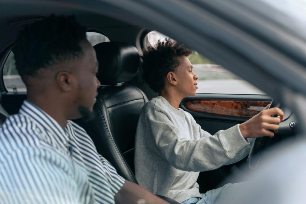 A photo of a young driver reviewing insurance options with a parent. — Nevada car insurance new drivers