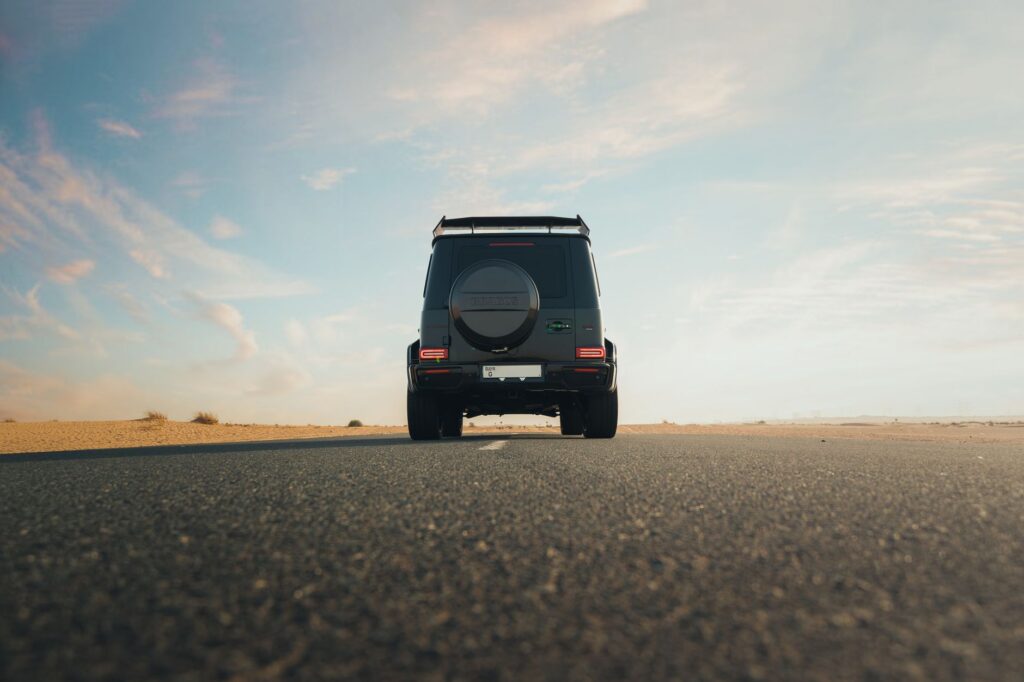 An image depicting a car driving through a desert landscape under a clear sky. — Nevada weather car insurance
