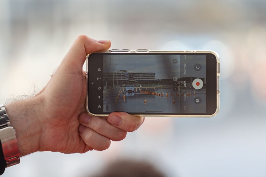 An image of a person documenting an accident scene with a smartphone — after car accident Nevada insurance