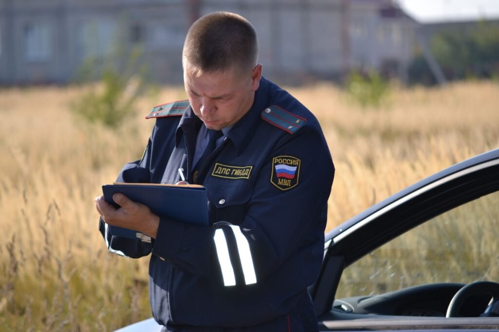 An image of a police officer taking notes at a car accident scene. — after car accident Nevada insurance