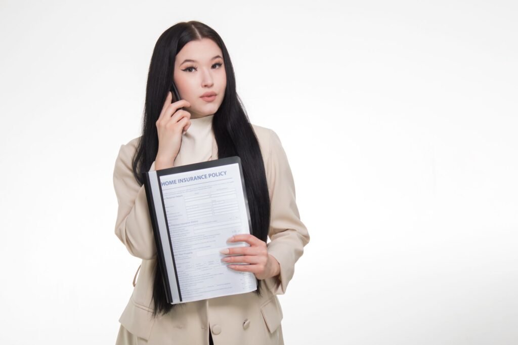 An image showing a person talking to an insurance agent over the phone about how to file a car insurance claim in Nevada. …