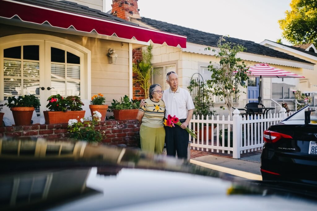 A happy family in front of their home and car, symbolizing the benefits of bundling insurance Nevada.