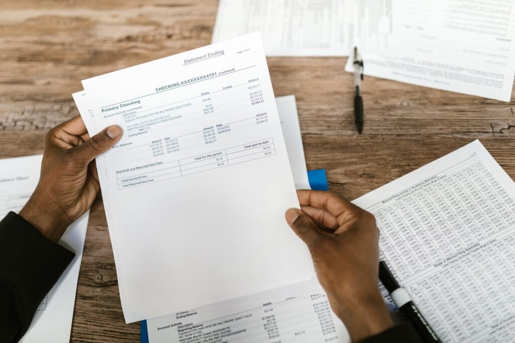 An image of a person reviewing their credit report with a calculator and car insurance documents. — credit score car ins…