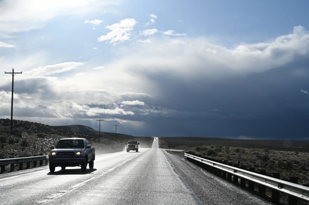 Image of a car driving on a Nevada highway during a storm — Nevada car insurance rates geography